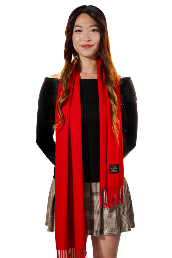 Ruby Echo lambswool scarf worn by model, featuring a bold solid red color, soft texture, and long fringed edges for a classic, statement look