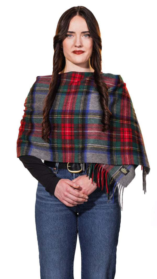 Model wearing Sterling Veil cashmere stole in a multicolor tartan plaid featuring red, deep green, navy blue, and grey 
