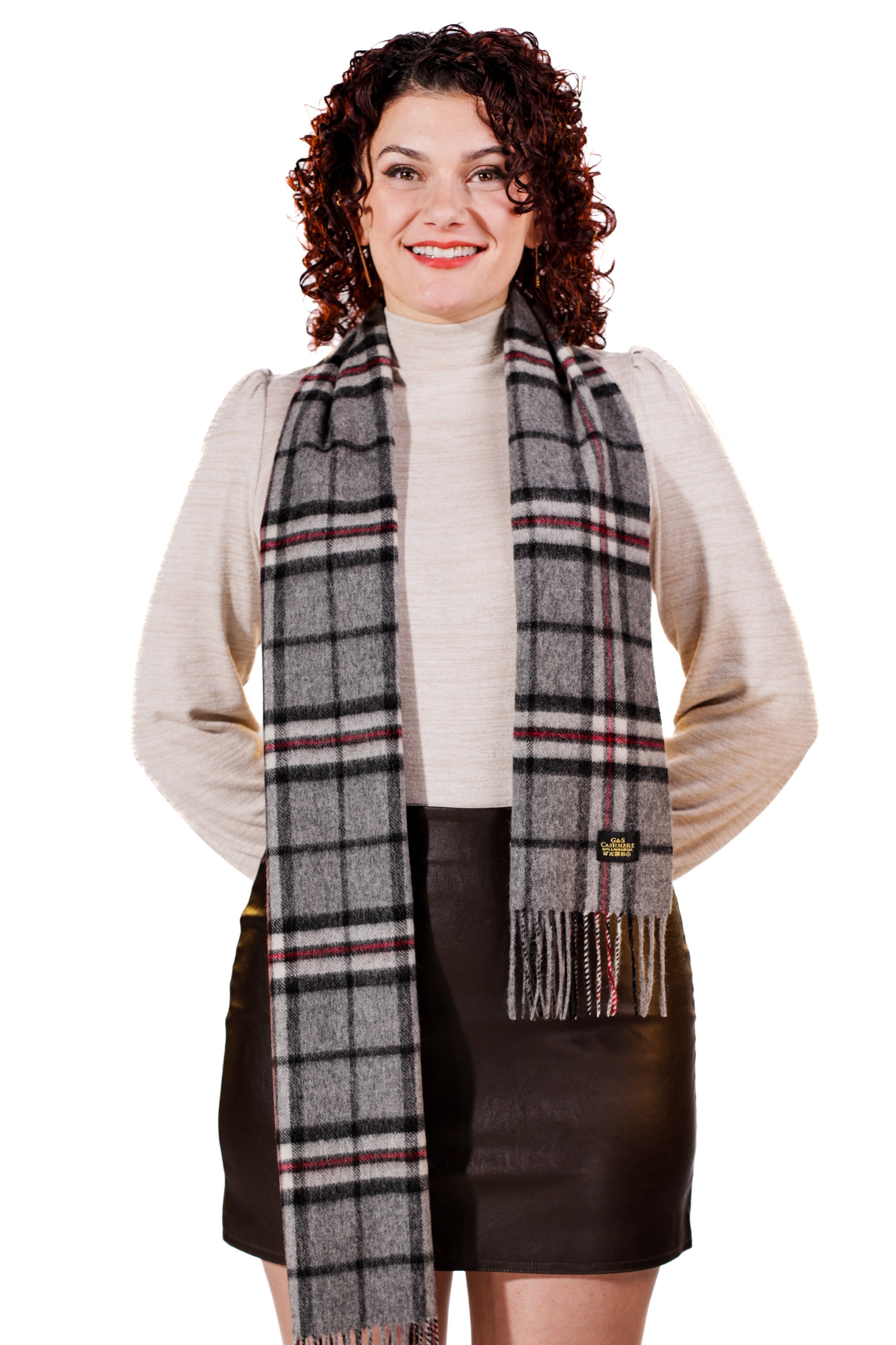 Woman wearing a plaid scarf with a visible brand logo on a white background